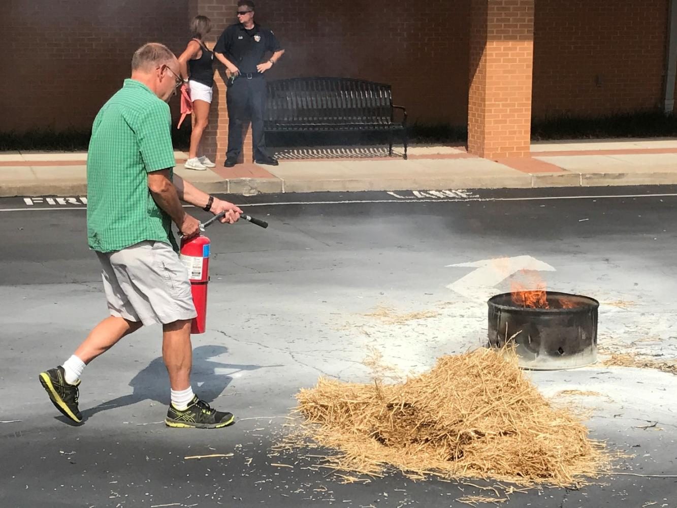 Mr. Bud Stein practices his fire extinguisher skills at the faculty in-service day on Aug. 10.