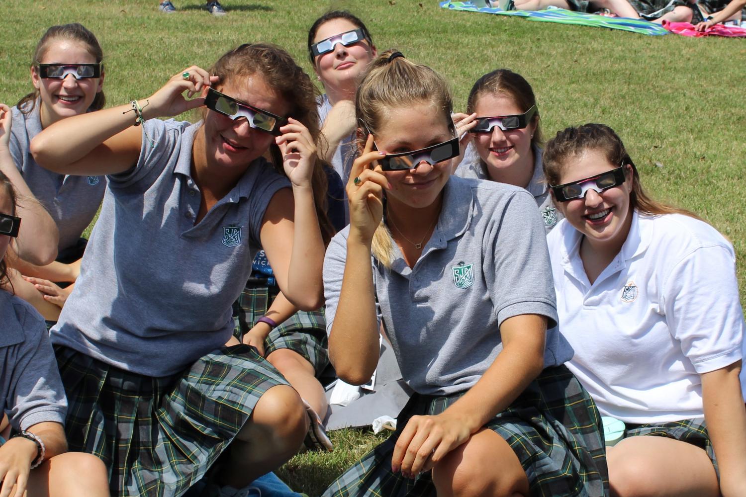 Students show off their glasses during the eclipse. 