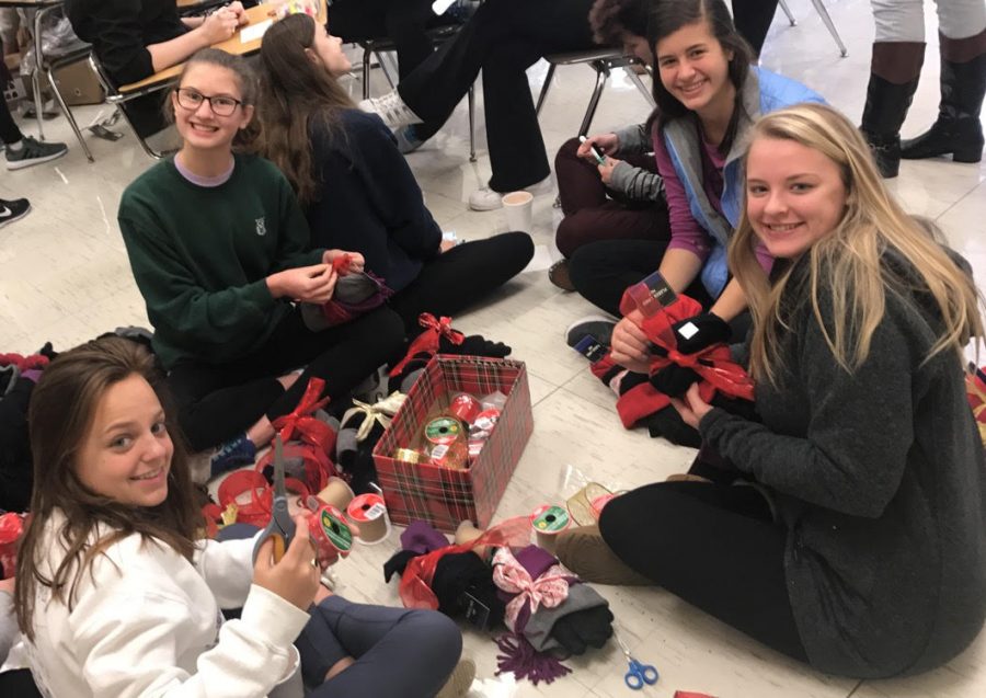 Students from all grades including Kristin Strout (junior), Chickie Slane (senior), Molly Boersig (senior), Olivia Sullivan (sophomore) and Sara Frautschi (freshman) gathered in Mrs. Jane Garvin’s classroom to sort hats, gloves, and scarves to be wrapped with Christmas ribbon and distributed to our dear neighbors at Saints Peter and Paul.  