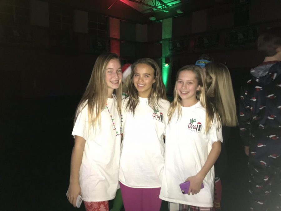Freshmen Grace Kinzel, Grace Becker, and Jenny Mansfield stop to take a picture for the yearbook at Chrismix.