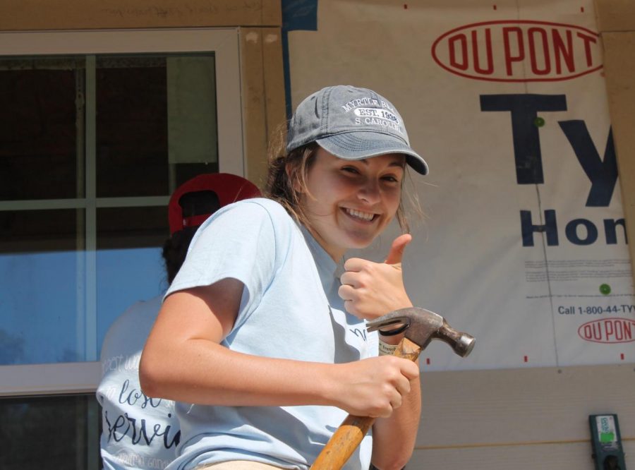 Mallory Holzer shows a big smile while working on the construction of a house during the 2017 New Orleans Spring Break Trip