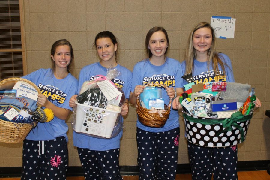 Last+years+sophomore+class+officers+sport+their+Mission+Week+gear+and+holding+their+raffle+baskets.