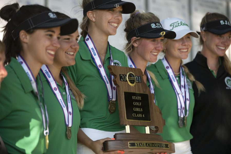 The golf team seen holding up the state trophy as they win the sixth state title.
