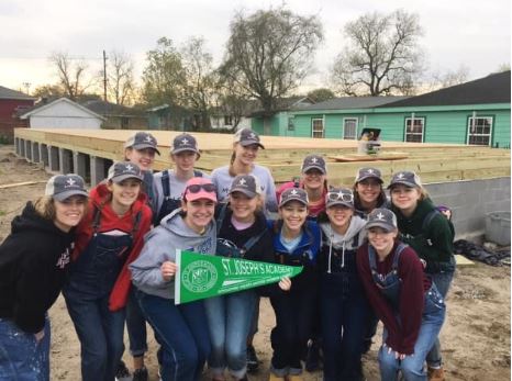 Angels in New Orleans smiling in front of the new house foundation they built in one week (2019)! 