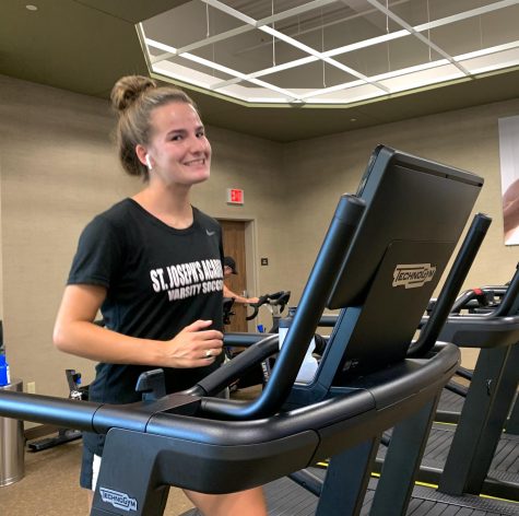 Senior Grace Kertz staying active during COVID-19 by walking on a treadmill.