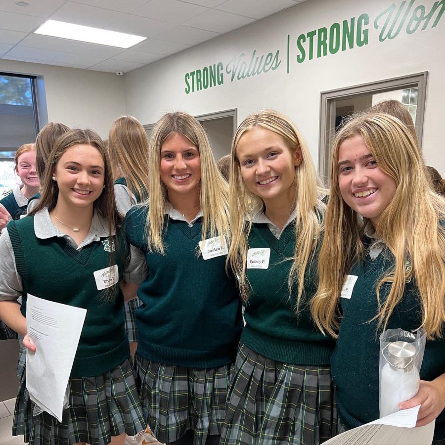 Sophomores Enza Bommarito, Jaiden Beckman, Sydney Peters, and Izzie Patritti smile during open house as they prepare to give tours to families.