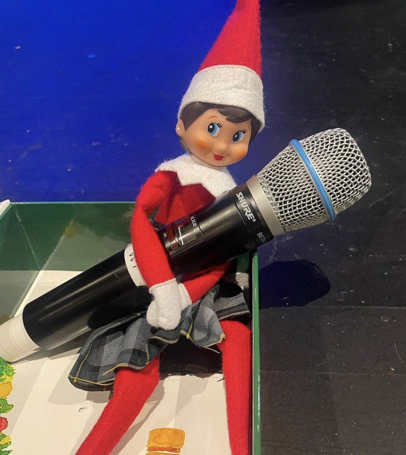 St Joes elf, Karen, holds a microphone. 