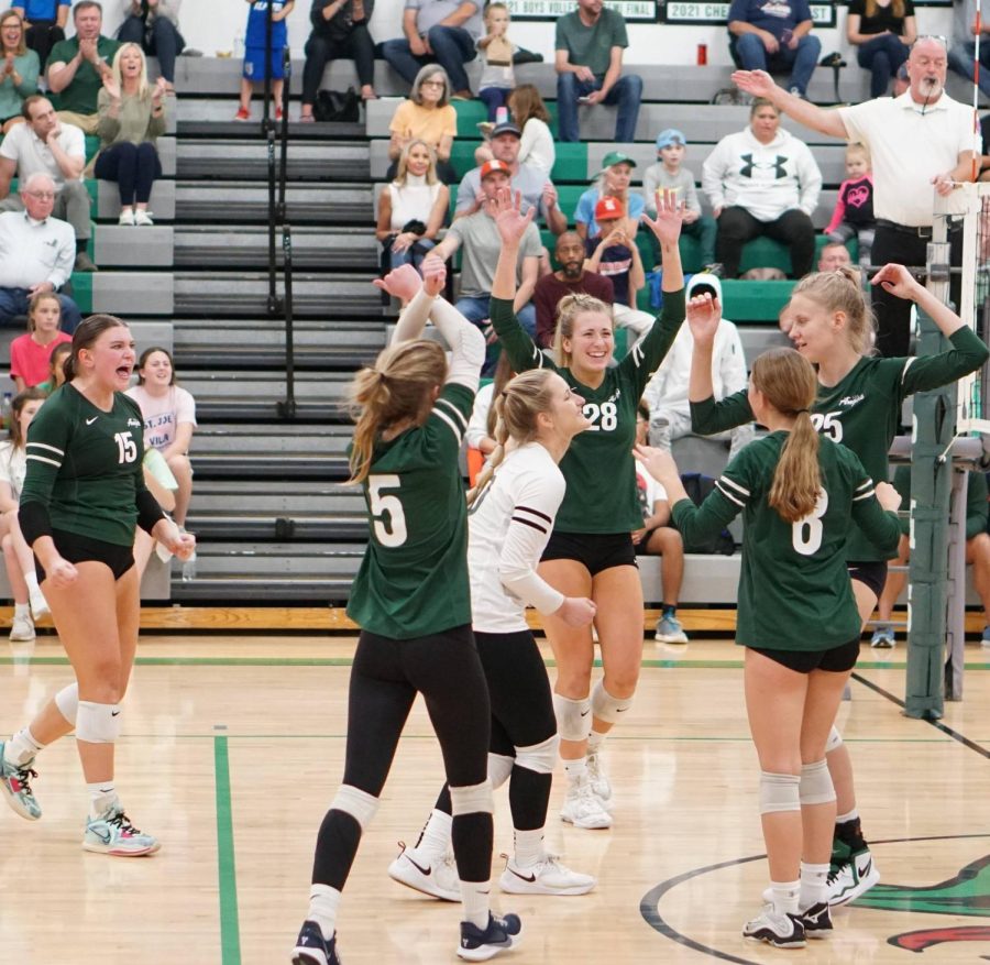 The varsity volleyball team celebrating on the court during the district semifinals against Francis Howell Central.