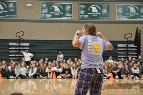Sophomore Anna Spalitto shows off the sophomore classs Mission Week clothing during the kickoff assembly.