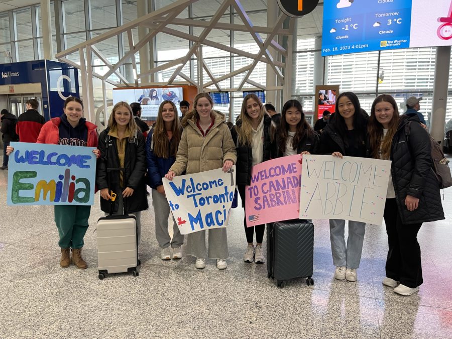 Abbie%2C+Emilia%2C+Sabrina%2C+and+Macie+being+greeted+at+the+airport+by+their+hosts%2C+Nicole%2C+Emily%2C+Sophia%2C+and+Charlotte.